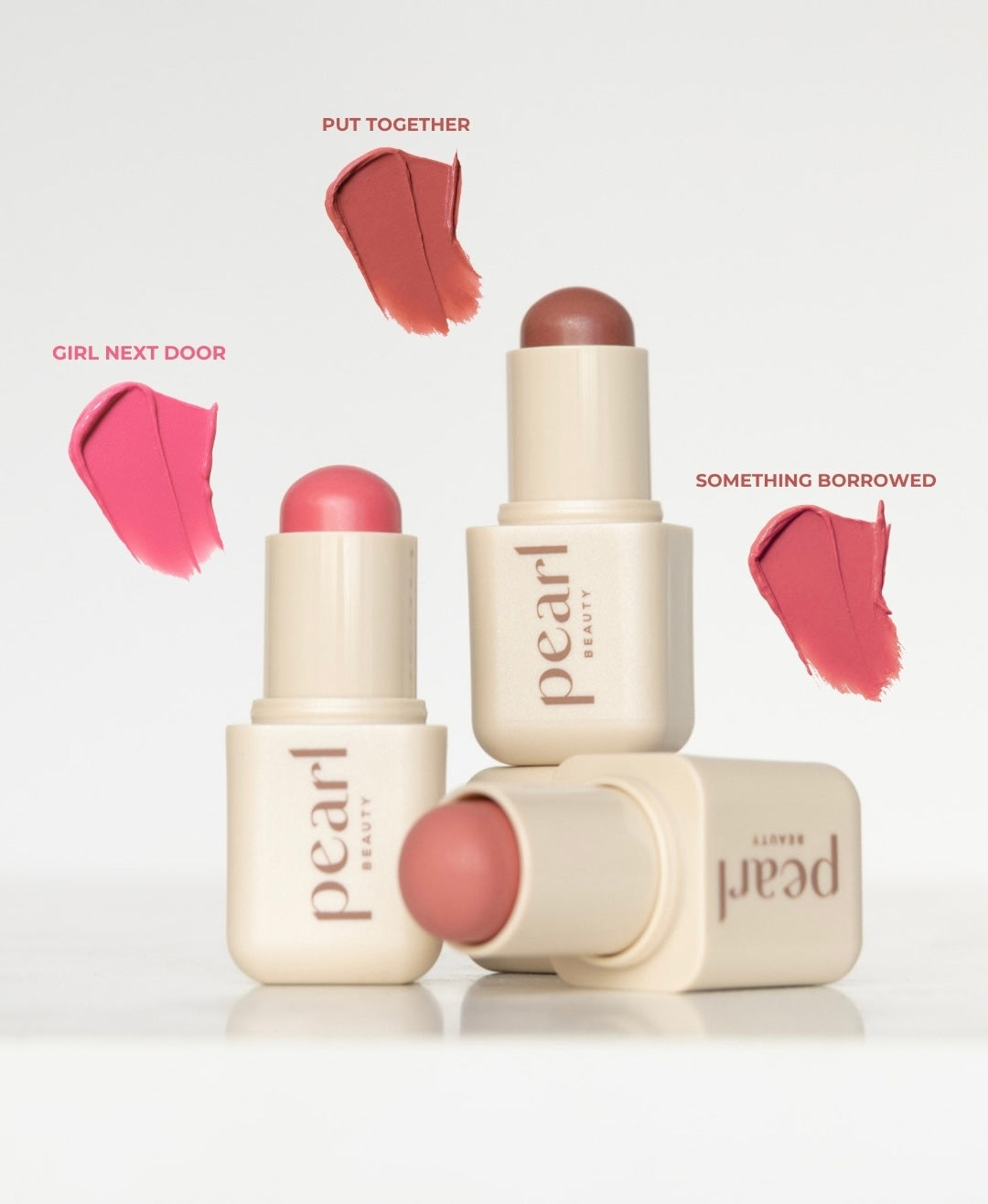 Three pearl beauty lip products with color swatches on a white background