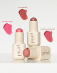 Three pearl beauty lip products with color swatches on a white background