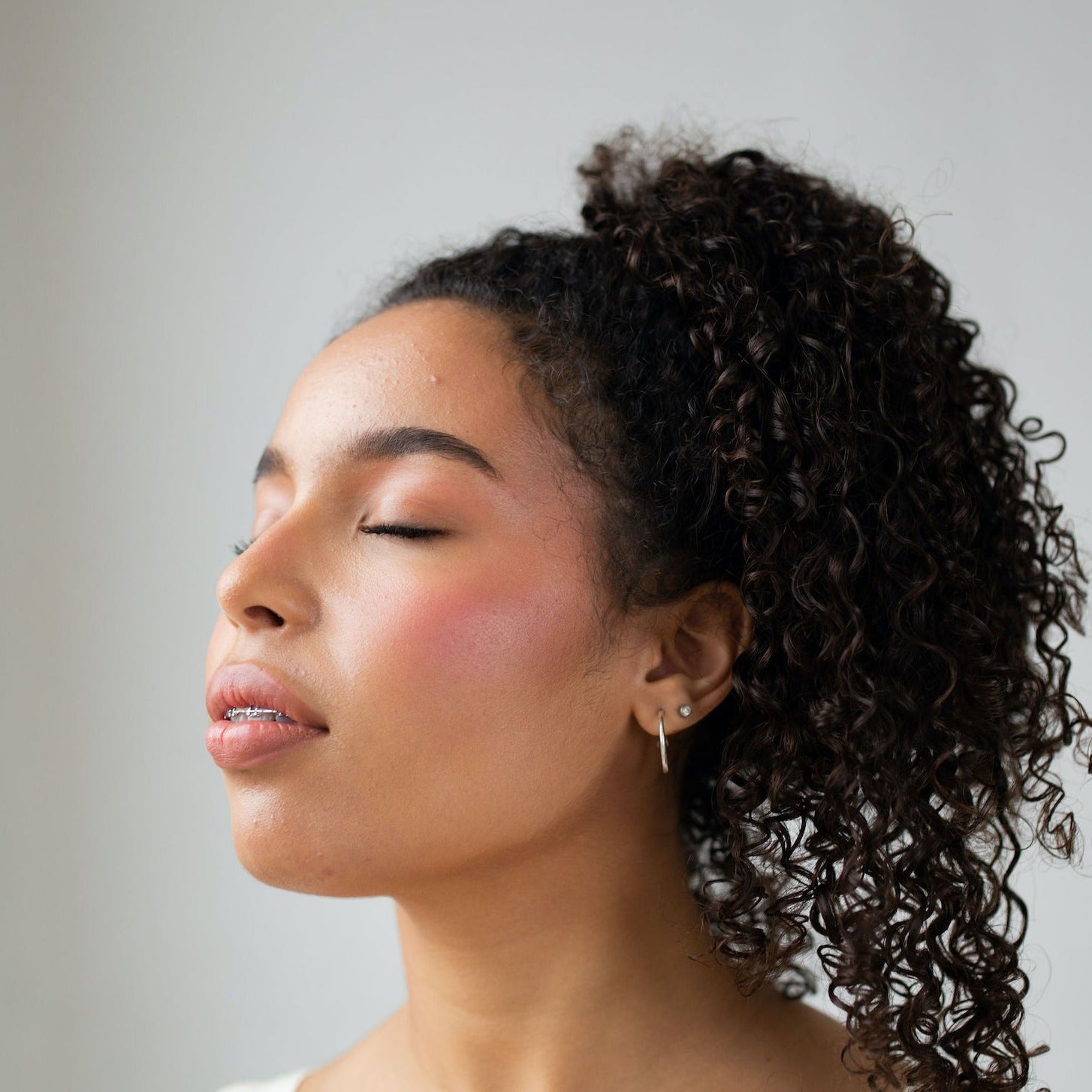 Young girl wears Pearl Beauty Core Four Girl Next Door multi purpose stick pale cool pink cream blush vegan cruelty-free