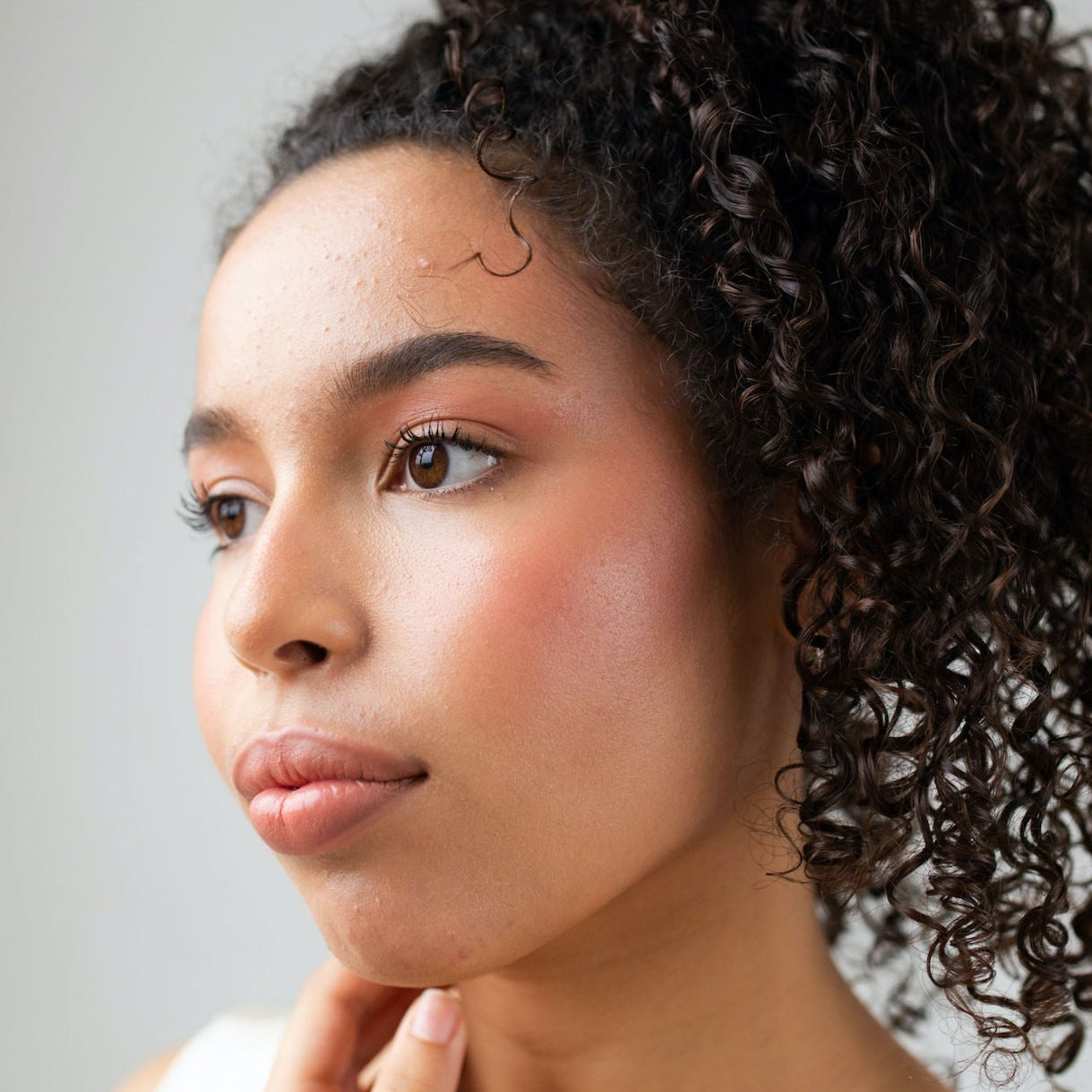 Close-up of young woman wearing Pearl Beauty Core Four Put Together cream blush stick medium rose colour cream blush vegan cruelty-free